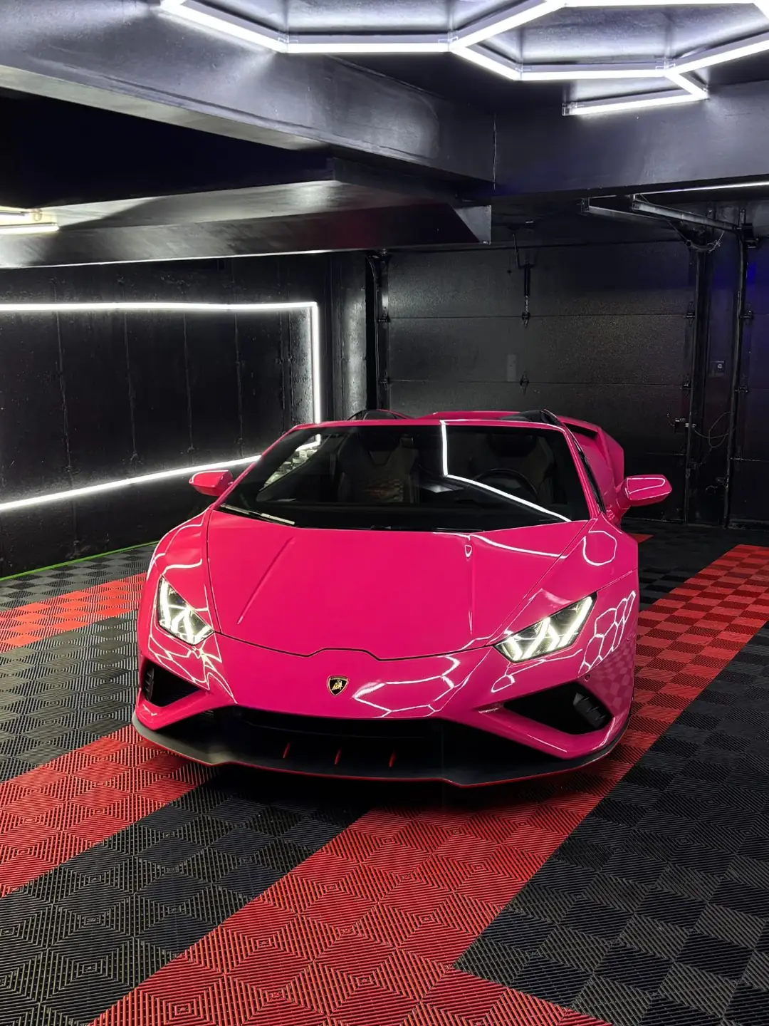 Pink Lamborghini Huracán EVO Spyder under the studio's hexagon lights